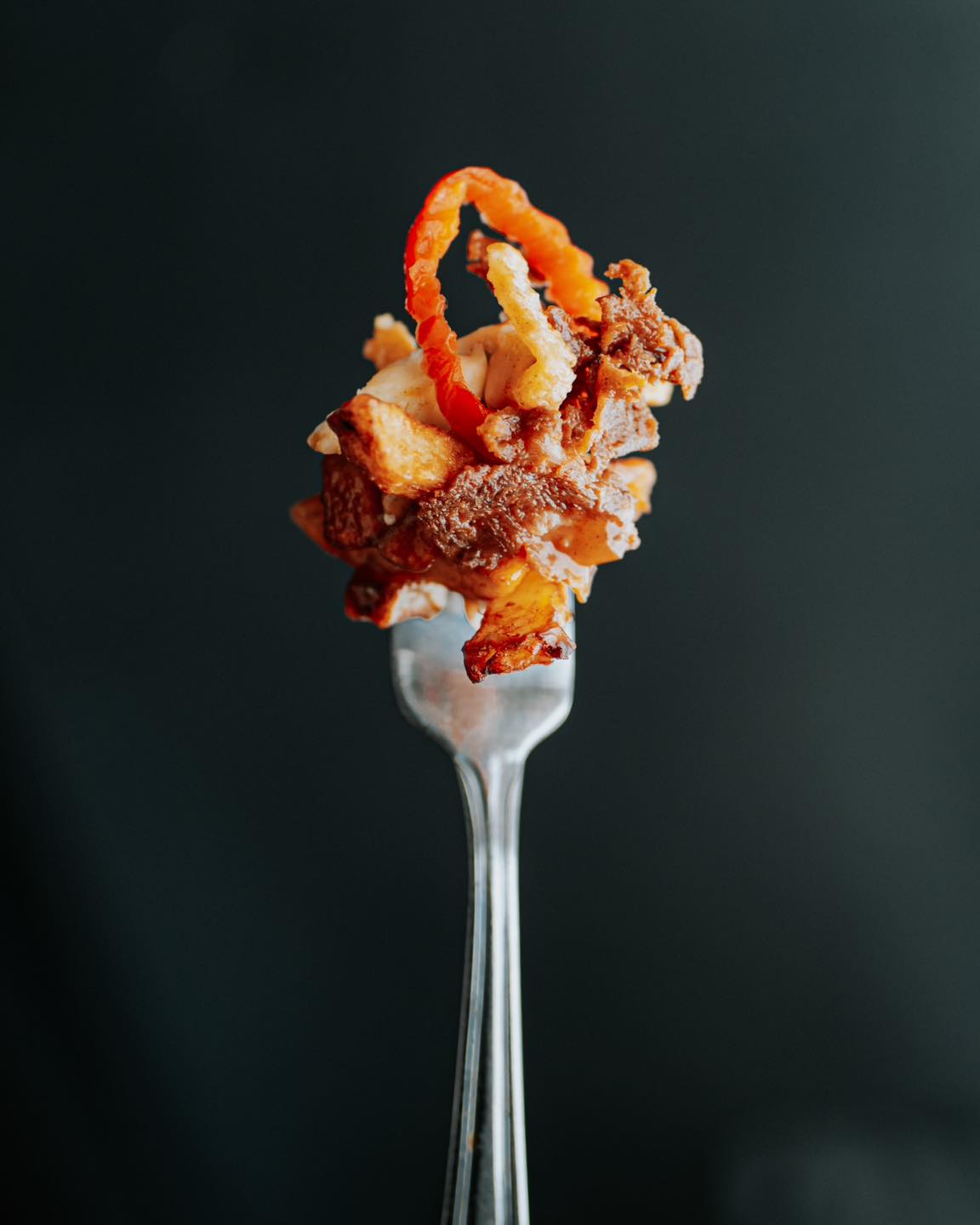 Poutine fumante servie sur ardoise sombre